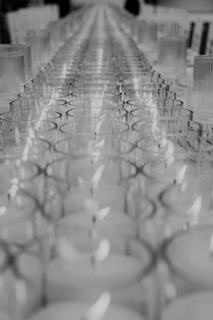 Decoración de evento en Lamarr Alicante con largas mesas iluminadas por cientos de velas blancas, diseño elegante junto a palmeras
