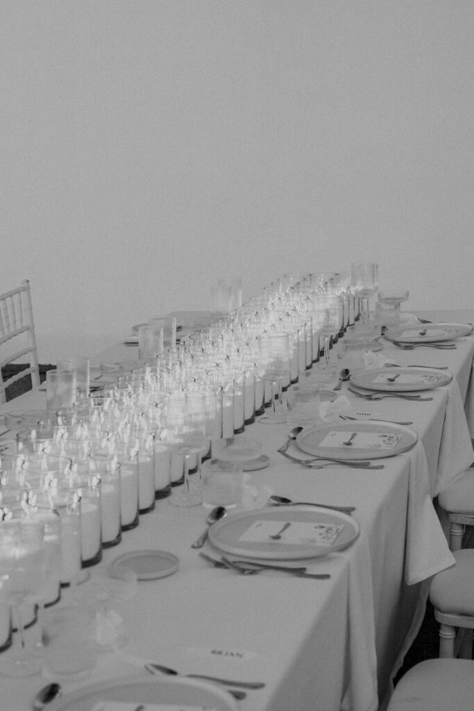 Decoración de evento en Lamarr Alicante con largas mesas iluminadas por cientos de velas blancas, diseño elegante junto a palmeras