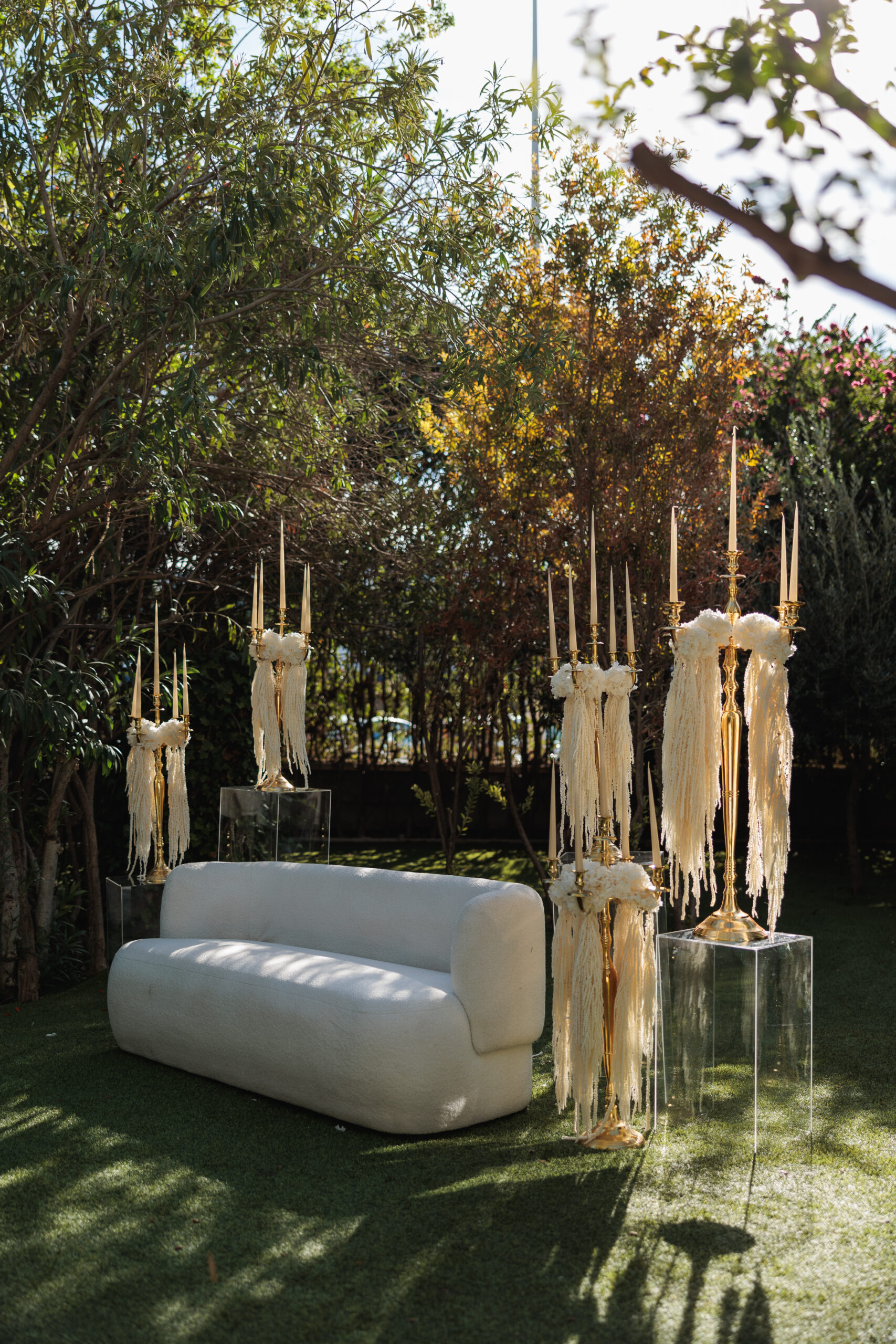 Montaje de evento con alquiler de velas largas, candelabros dorados y decoración con lazos.