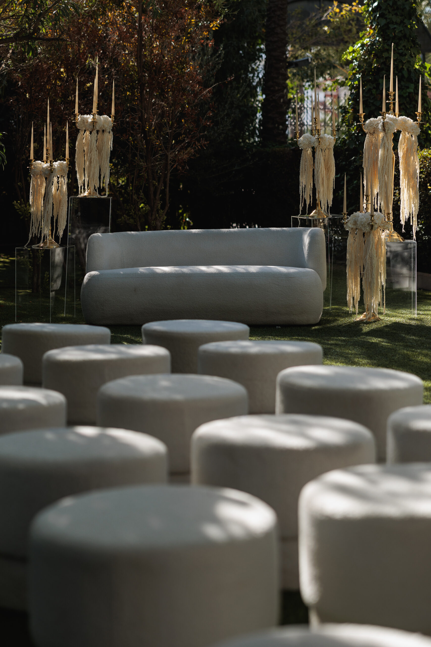 Montaje de evento con alquiler de velas largas, candelabros dorados y decoración con lazos.