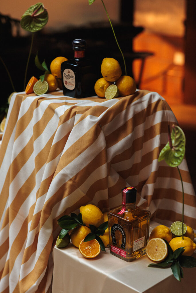 Decoración de evento en Uppery Club Málaga con mesa larga, velas encendidas, cítricos frescos y flores en tonos cálidos