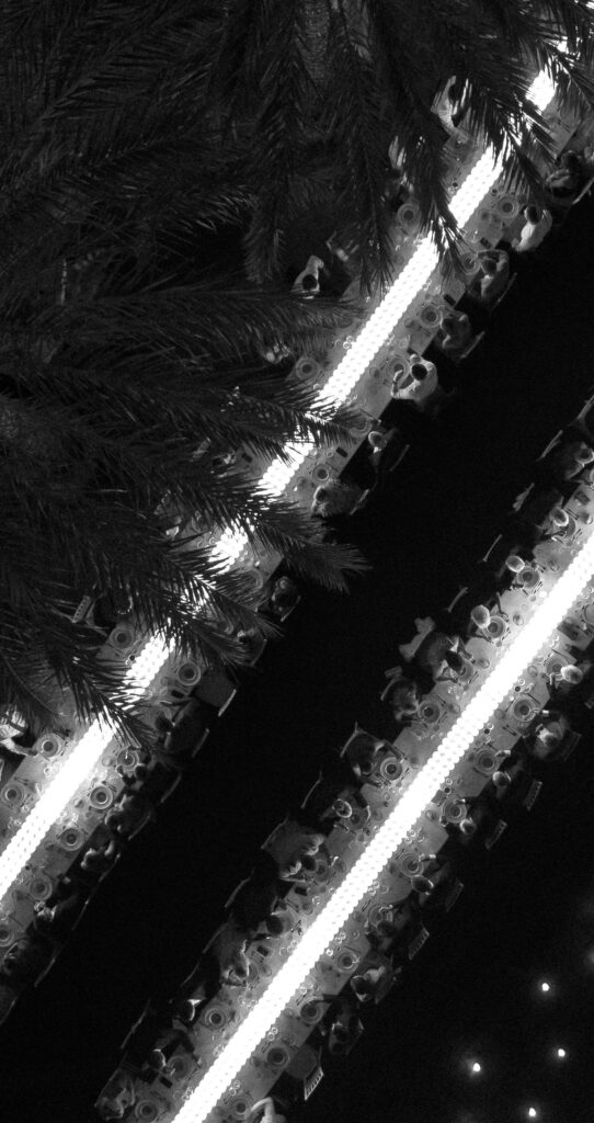 Decoración de evento en Lamarr Alicante con largas mesas iluminadas por cientos de velas blancas, diseño elegante junto a palmeras